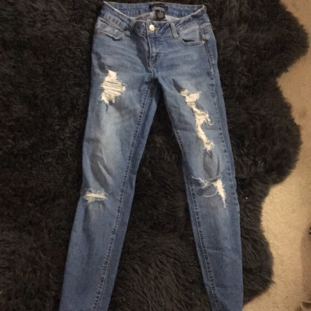 Mid rise, ripped, medium wash skinny jeans.
